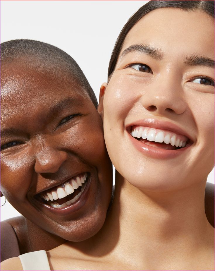 Two people smiling with glowing skin